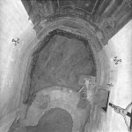 Apsida rotundy (dole) a základy gotického presbytáře (nahoře), mezi nimi odkryté hroby. Pohled shora do interiéru kostela. Autor neznámý; © NPÚ Praha.